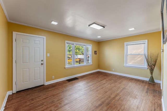 empty room featuring ornamental molding and hardwood / wood-style floors