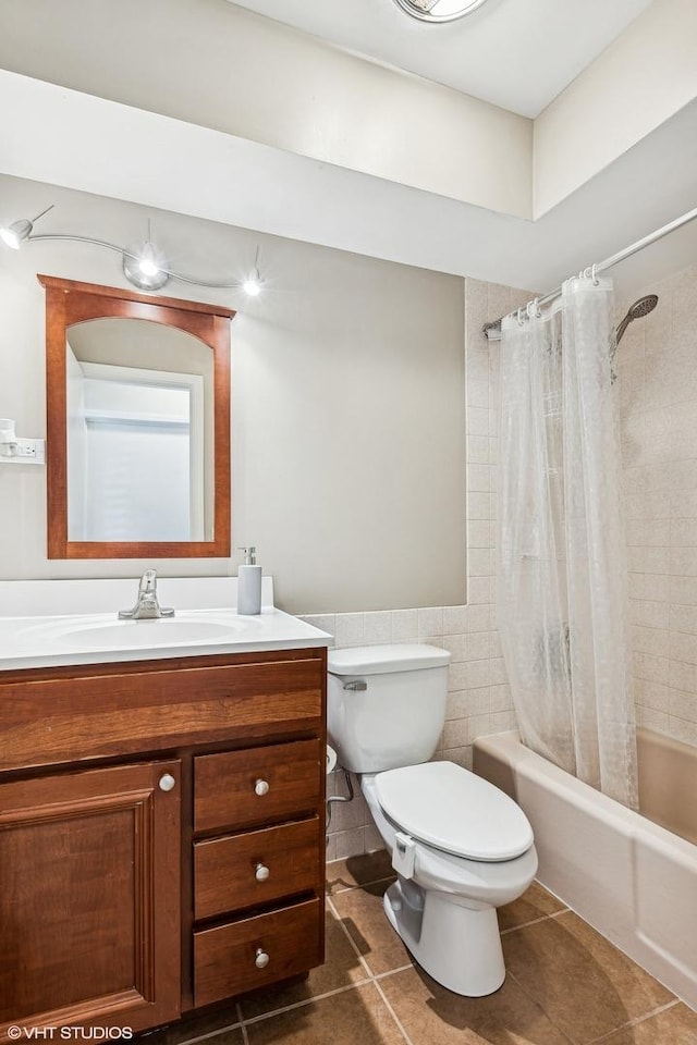 full bathroom with toilet, tile walls, tile patterned floors, vanity, and shower / bathtub combination with curtain