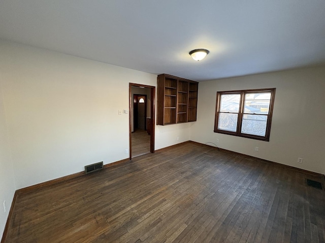 empty room with dark hardwood / wood-style flooring