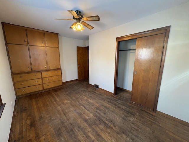 unfurnished bedroom with dark hardwood / wood-style flooring, ceiling fan, and a closet