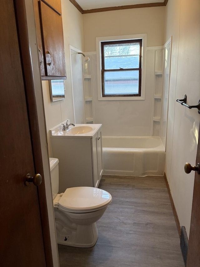 full bathroom with washtub / shower combination, toilet, crown molding, vanity, and hardwood / wood-style flooring