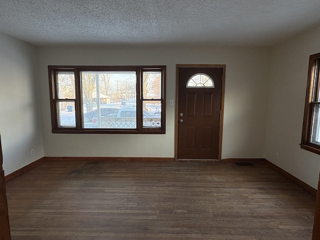 foyer entrance featuring dark wood-type flooring and a textured ceiling