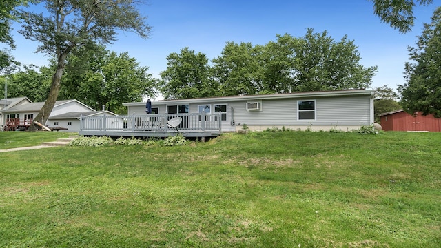 manufactured / mobile home with a wall unit AC, a deck, and a front lawn