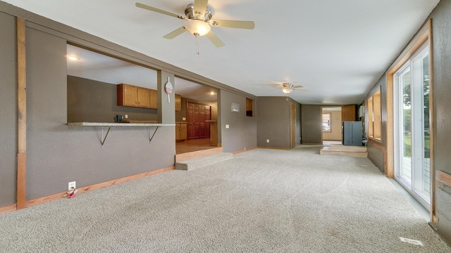 unfurnished living room with ceiling fan and light colored carpet