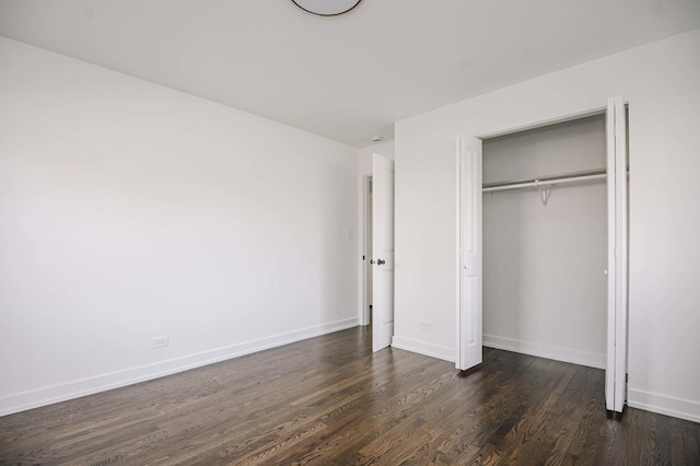 unfurnished bedroom with a closet and dark hardwood / wood-style flooring