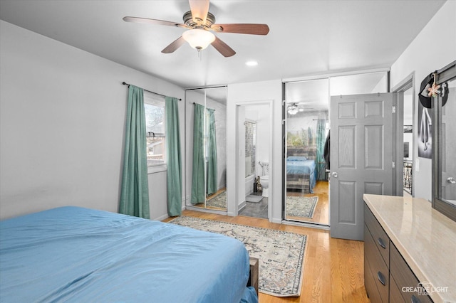 bedroom with ceiling fan, light hardwood / wood-style flooring, and ensuite bath