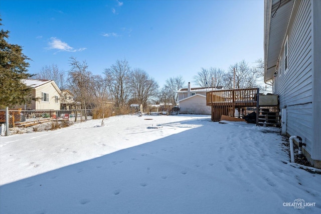 yard covered in snow with a wooden deck