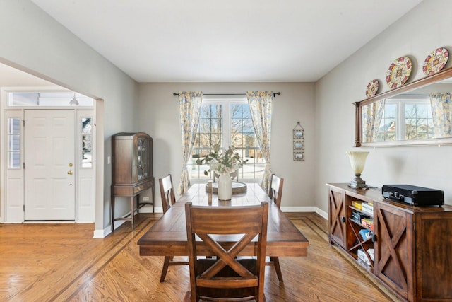 dining area with plenty of natural light and light hardwood / wood-style flooring