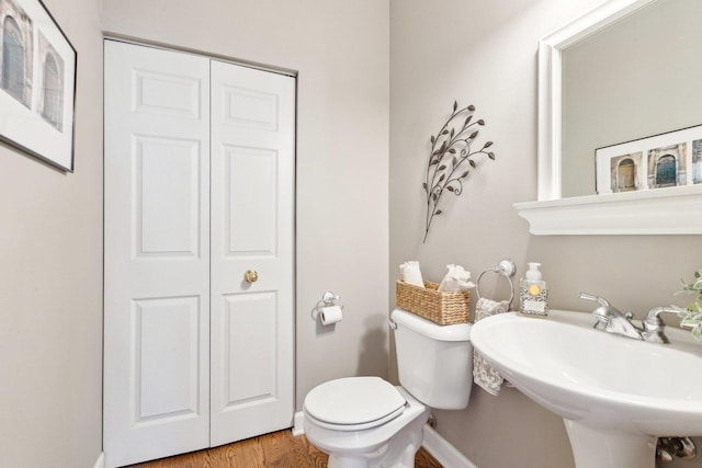 bathroom with hardwood / wood-style floors, sink, and toilet