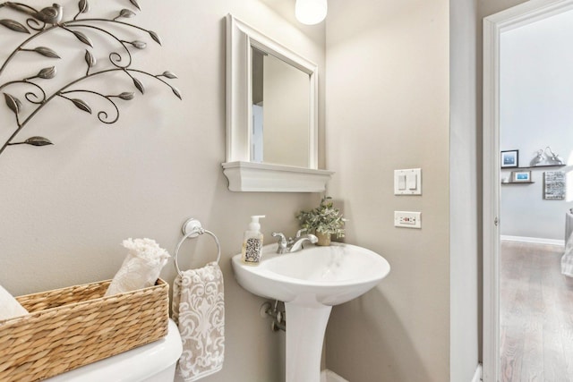 bathroom with hardwood / wood-style floors and toilet