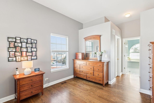 interior space with dark wood-type flooring and connected bathroom