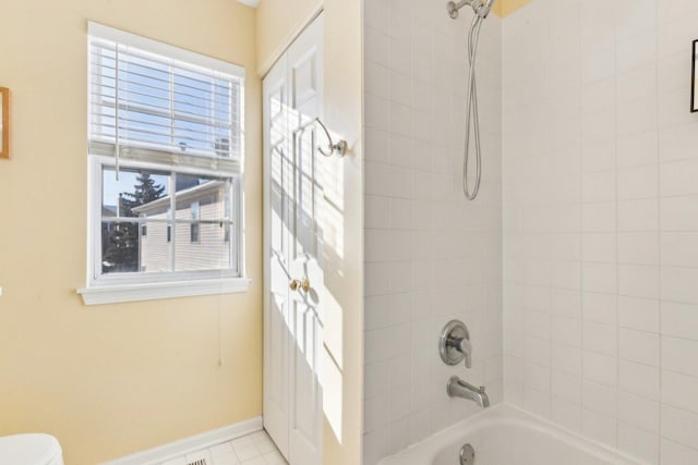 bathroom featuring tiled shower / bath and toilet