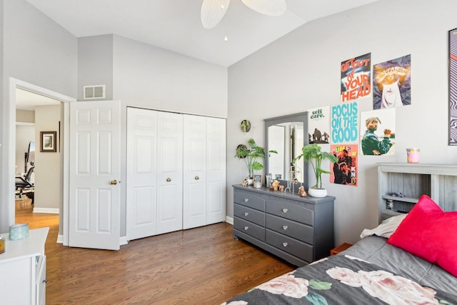 bedroom with dark wood-type flooring, high vaulted ceiling, a closet, and ceiling fan