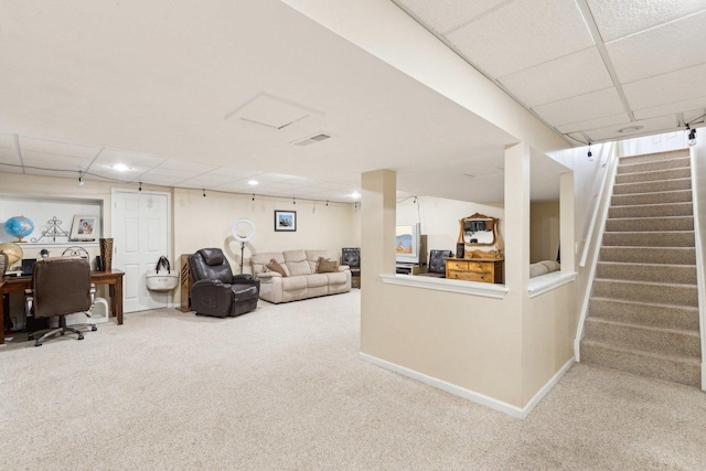 living room with a paneled ceiling and carpet