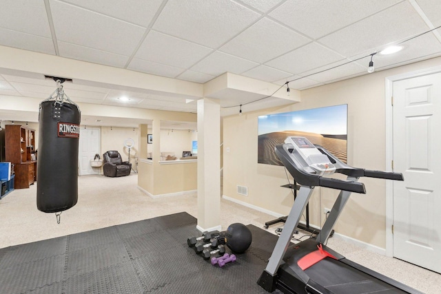 exercise room with carpet floors and a drop ceiling