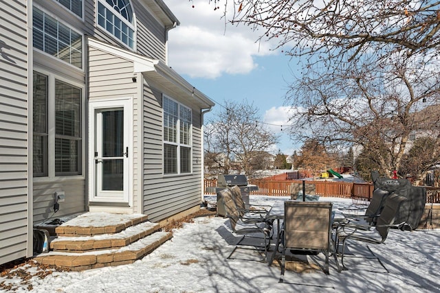 snow covered patio with a grill