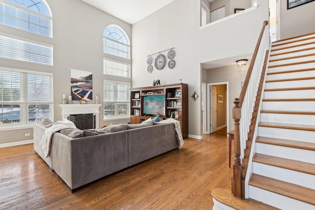 living room featuring a towering ceiling and wood-type flooring