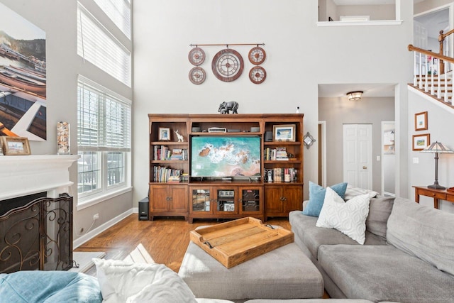 living room with light hardwood / wood-style floors and a high ceiling