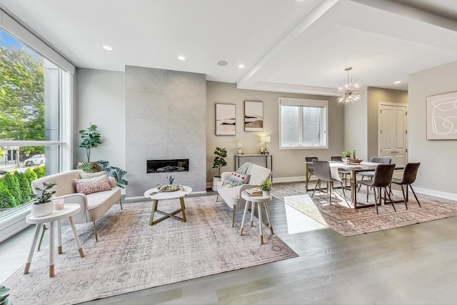 living room with a notable chandelier, a fireplace, and hardwood / wood-style flooring