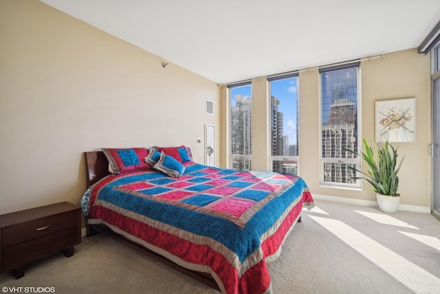 carpeted bedroom featuring a city view, visible vents, and baseboards