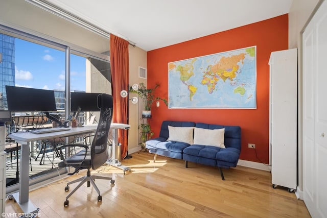 office with baseboards, visible vents, and wood finished floors