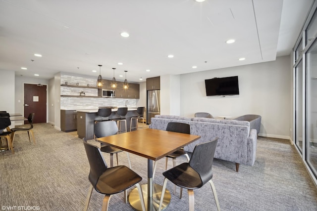 dining area featuring baseboards, light colored carpet, and recessed lighting