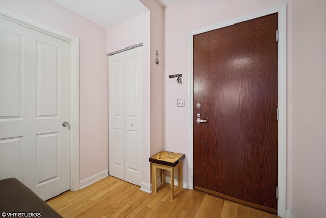 entryway with light wood-style flooring and baseboards