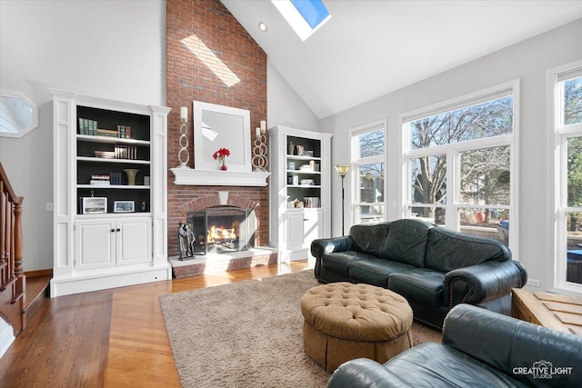 living room with a brick fireplace, high vaulted ceiling, a skylight, and hardwood / wood-style flooring