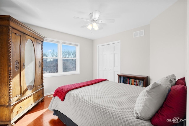 bedroom featuring ceiling fan, a closet, and hardwood / wood-style flooring