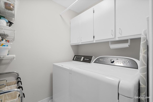 laundry room with washing machine and dryer and cabinets