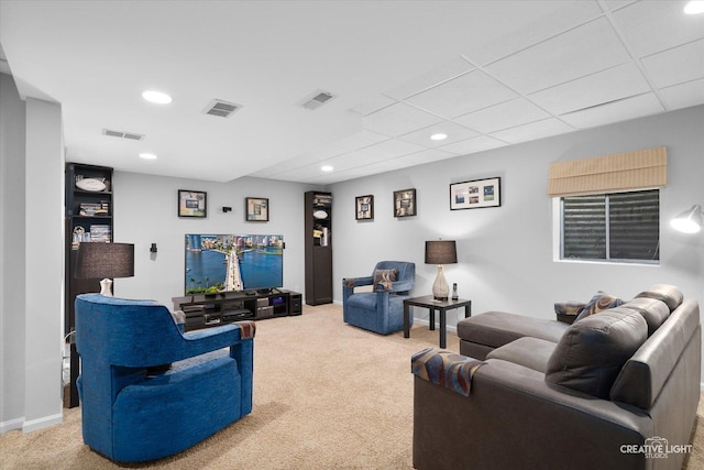 living room featuring a paneled ceiling and carpet flooring