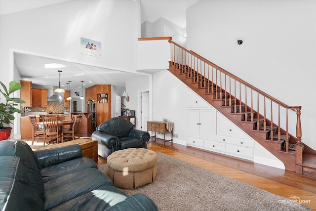 living room featuring light hardwood / wood-style floors and a towering ceiling