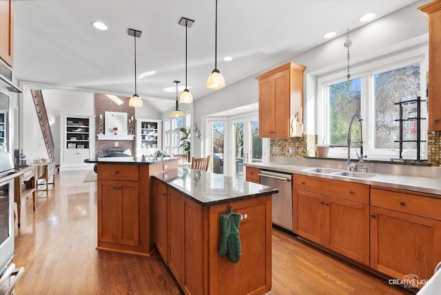 kitchen featuring sink, a center island, dishwasher, decorative backsplash, and hanging light fixtures