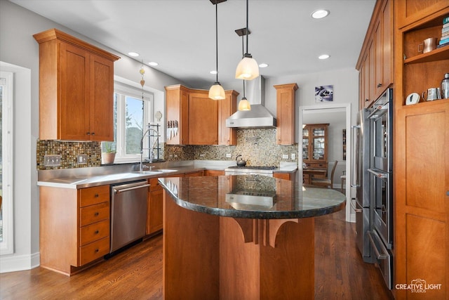 kitchen with dark wood-type flooring, stainless steel dishwasher, wall chimney exhaust hood, a kitchen island, and sink