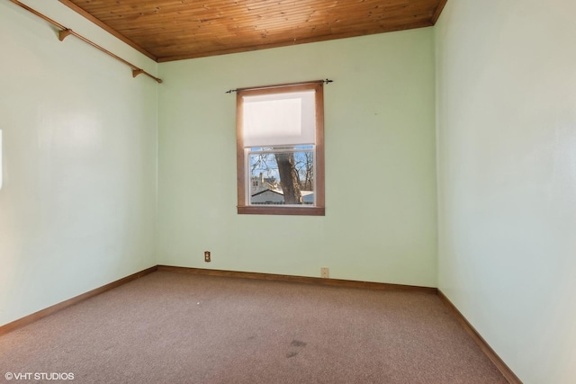 carpeted empty room featuring wooden ceiling