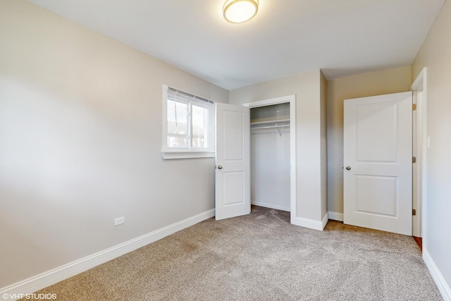 unfurnished bedroom featuring light colored carpet and a closet