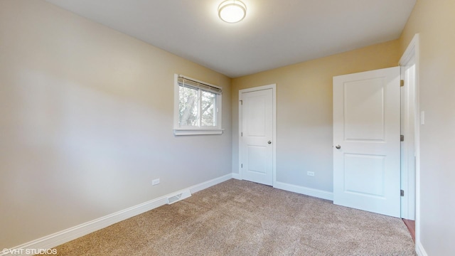 unfurnished bedroom with a closet and light carpet