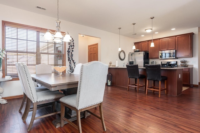 dining room featuring dark hardwood / wood-style floors and a chandelier