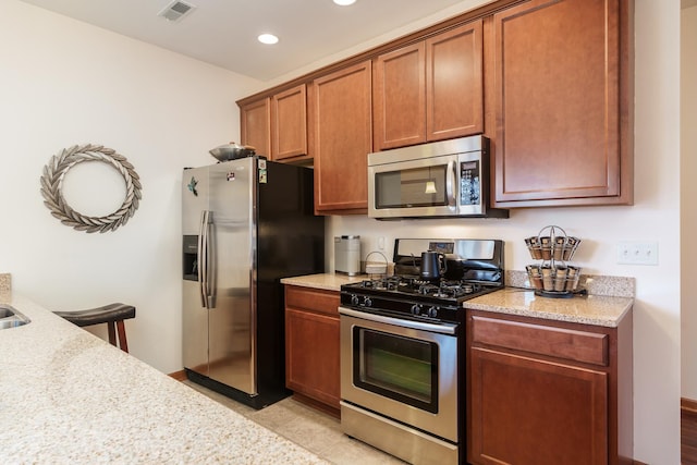 kitchen featuring light stone countertops and stainless steel appliances