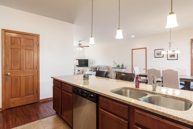 kitchen with dishwasher, hanging light fixtures, light stone countertops, ceiling fan with notable chandelier, and sink