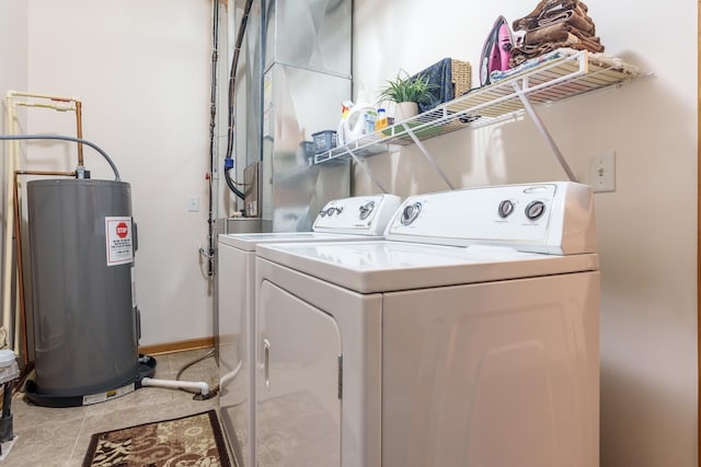 laundry room with tile patterned floors, washer and clothes dryer, and water heater