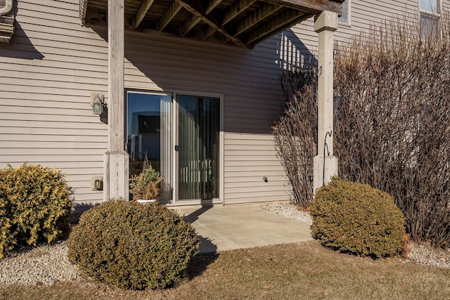 view of exterior entry with a patio area