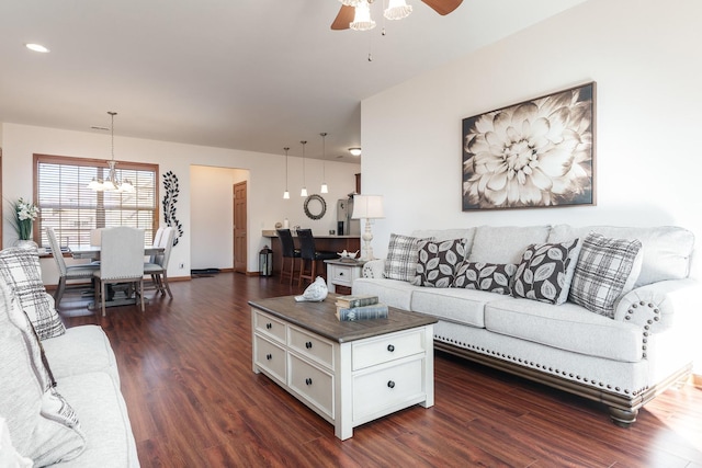 living room featuring dark hardwood / wood-style flooring and ceiling fan with notable chandelier