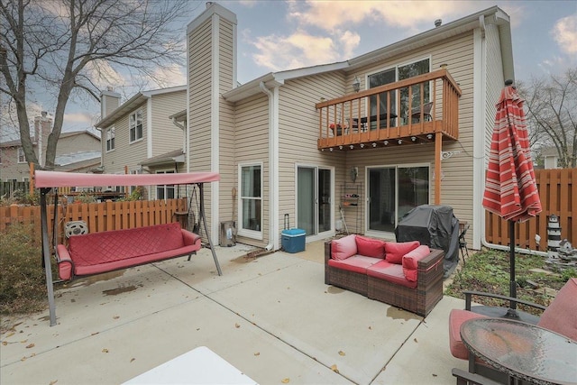 rear view of house featuring a balcony and a patio