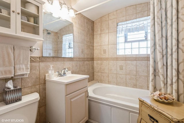 full bathroom with toilet, vanity, tile walls, and shower / bath combination with curtain