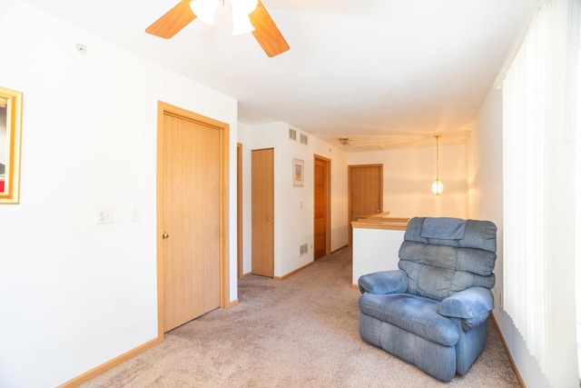 sitting room featuring ceiling fan and light colored carpet