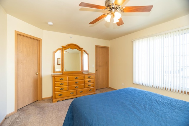 bedroom with ceiling fan and light carpet