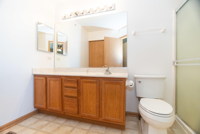 bathroom with a shower with door, vanity, and toilet