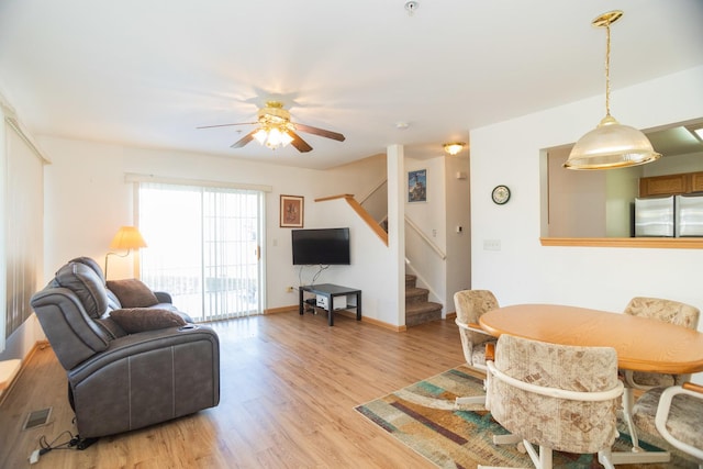 living room featuring ceiling fan and light hardwood / wood-style floors