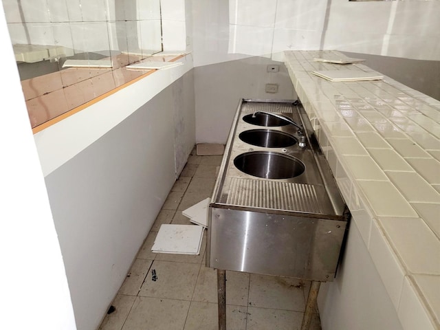 kitchen featuring light tile patterned floors, white cabinets, and tile countertops